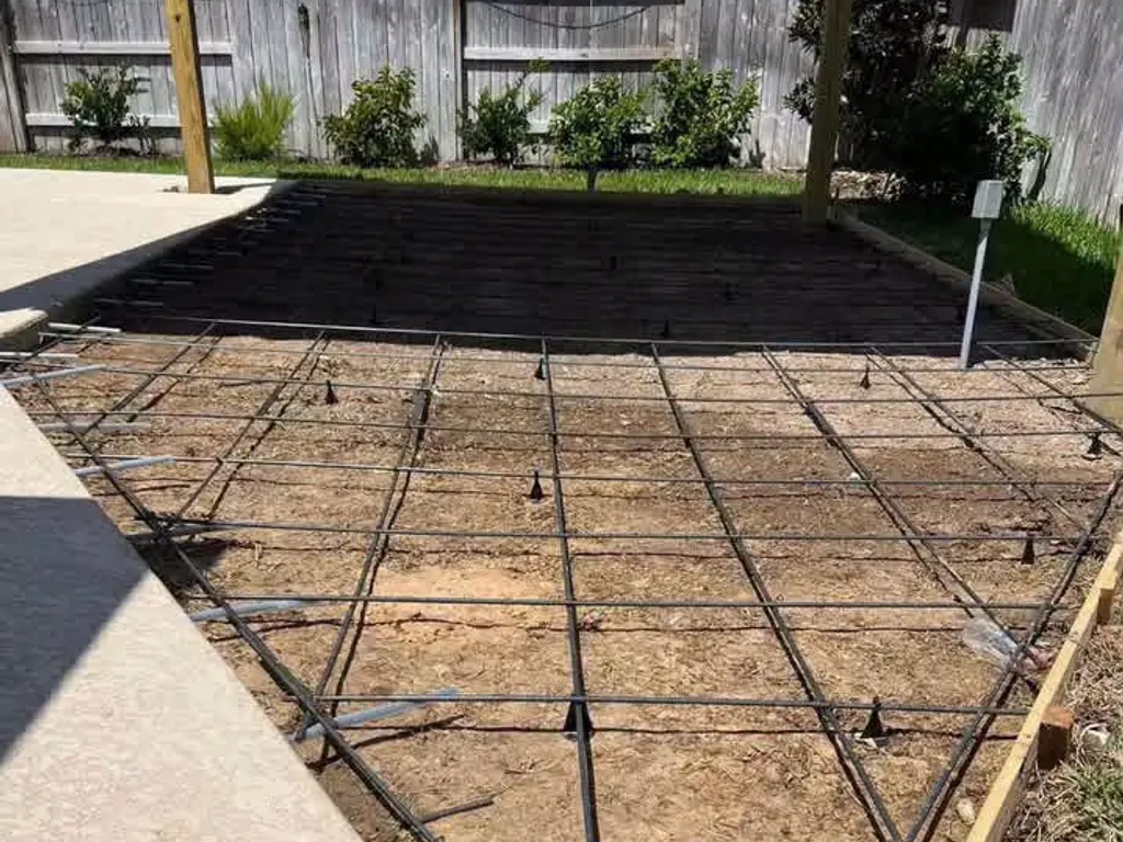 Rebar grid set on chairs inside wood forms before a concrete slab pour