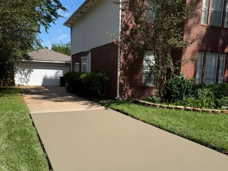 New concrete driveway next to a brick home